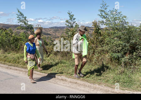 Tragen waren auf dem Kopf. Blick entlang der N7 in Ranomafana Antsirabe Madagaskar Stockfoto