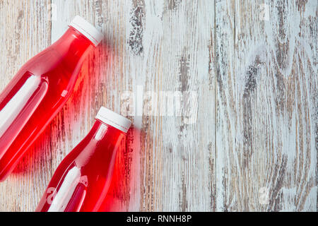 Kunststoff Sodaflasche berry juice Drink auf Holz- Hintergrund. Ein paar Gallonen erfrischende Berry trinken. Die Aussicht von oben. kopieren. Stockfoto