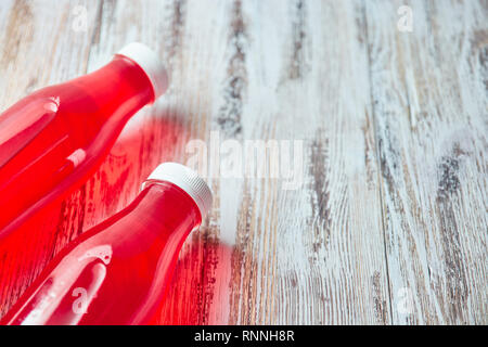 Kunststoff Sodaflasche berry juice Drink auf Holz- Hintergrund. Ein paar Gallonen erfrischende Berry trinken. Die Aussicht von oben. kopieren. Stockfoto