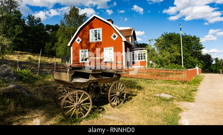 Alte Kutsche vor rot Holz- Landwirtschaft Haus auf dem Hof Katthult in Lönneberga, Schweden, Michel, Astrid Lindgren Stockfoto