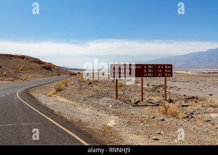 Schild angegebenen Entfernungen, wie sie in Richtung Badwater Basin von Furnace Creek, Virginia, United States. Stockfoto