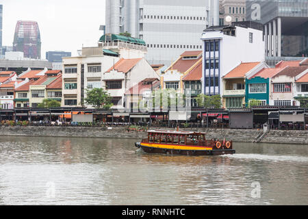 Wasser Taxi auf dem Singapore River. Boat Quay, ehemaligen Shop Häuser jetzt Restaurants und Bars. Gebäude der Financial District im Hintergrund. Singapur. Stockfoto