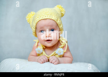 Porträt einer niedlichen neugeborenen Baby Mädchen in gelb Strickmütze Stockfoto