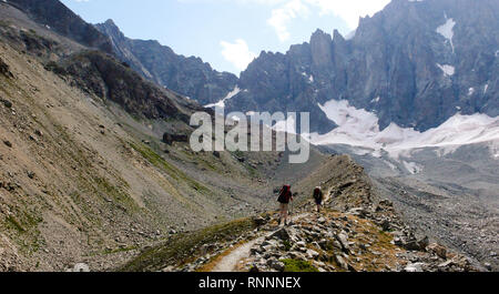 Zwei Wanderer und Bergsteiger wandern auf einem Gletscher Moräne auf dem Weg zum Base Camp in den Französischen Alpen Stockfoto