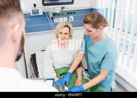 Patienten im Aufwachraum der Klinik im Gespräch mit Arzt Stockfoto