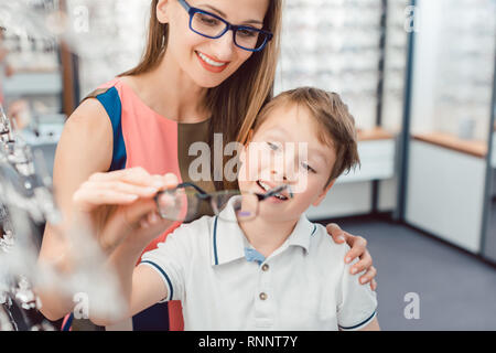 Mutter und Sohn beide mögen die Brillen in Optiker Shop angeboten Stockfoto