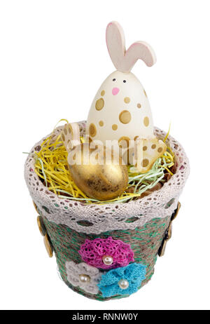 Fröhliche handgefertigten Holzmöbeln Osterhase bewacht eine goldene Wachtel Ei. Auf weissem studio Makro isoliert Stockfoto