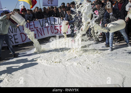 Februar 17, 2019 - Messina, Sizilien, Italien - Hirten werden gesehen, gießen Dosen von Milch auf die Straße während des Protestes.. Die sizilianische Milch producerâ € ™ s Protest in Dittaino, gegen die niedrigen Preis der Milch und der Wettbewerb von der Milch, die in den anderen Ländern hergestellt. Die Produzenten strömten mehr als 2000 Würfe von Milch auf die Straße und versuchte, die Autobahn Palermo-Catania zu blockieren. (Bild: © Danilo Campailla/SOPA Bilder über ZUMA Draht) Stockfoto