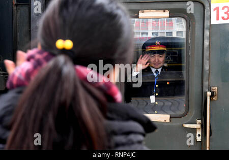 (190220) - Peking, Februar 20, 2019 (Xinhua) - Zhu Kangyu, der wie ein Zug Attendant arbeitet, Wellen zu seiner Frau Liu Xiaojing am Bahnhof in Zhengzhou Zhengzhou, der Central China Provinz Henan, 19.02.2019. Wie die K 4364 Zug zieht in die Zhengzhou Bahnhof, Liu Xiaojing, der mehr als sechs Monate schwanger, wenden Sie sich Ihrem Mann auf der Plattform am Tag der chinesischen Laternenfest, ein Tag zu treffen symbolisiert Familientreffen. Der Ehemann Zhu Kangyu besetzt ist auf dem Zug während der jährlichen Frühjahrstagung des Festival reisen Rush dienen. Nach über zwei Wochen nach der Trennung, die Paare h Stockfoto