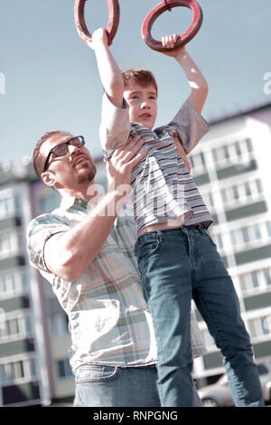 Vater hilft seinem Sohn bis auf die Leiste zu fangen Stockfoto