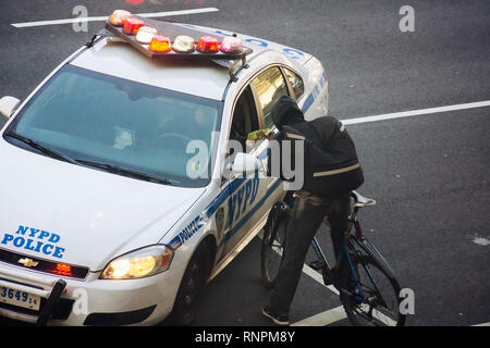 NYPD Officers ein Ticket für einen Radfahrer auf unbestimmte Verletzung im Fahrrad Lane auf 9. Avenue im New Yorker Stadtteil Chelsea am Samstag, 9. Februar 2019. (© Richard B. Levine) Stockfoto