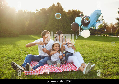 Eltern wollen Kinder zum Geburtstag im Park. Stockfoto