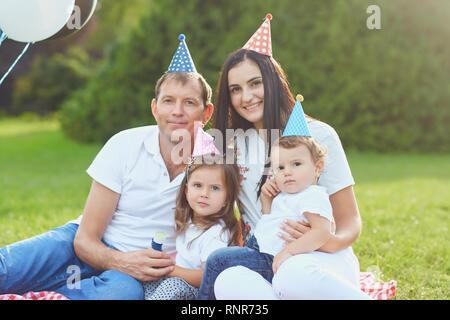 Eltern wollen Kinder zum Geburtstag im Park. Stockfoto