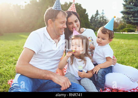 Eltern wollen Kinder zum Geburtstag im Park. Stockfoto