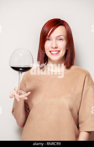 Junge schöne rothaarige Mädchen Sommelier und lächelnd Glas Rotwein am professionellen Blindverkostung sommelier Wettbewerb. Konzept Alkoholismus Stockfoto