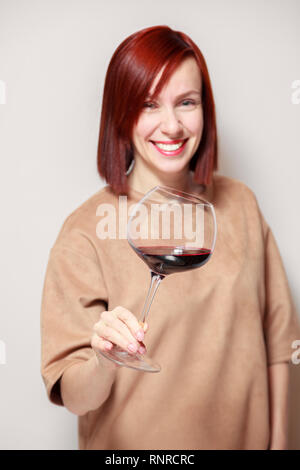 Junge schöne rothaarige Mädchen Sommelier und lächelnd Glas Rotwein am professionellen Blindverkostung sommelier Wettbewerb. Konzept Alkoholismus Stockfoto