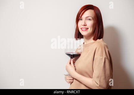 Junge schöne rothaarige Mädchen Sommelier und lächelnd Glas Rotwein am professionellen Blindverkostung sommelier Wettbewerb. Konzept Alkoholismus Stockfoto