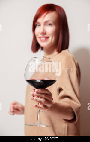 Junge schöne rothaarige Mädchen Sommelier und lächelnd Glas Rotwein am professionellen Blindverkostung sommelier Wettbewerb. Konzept Alkoholismus Stockfoto