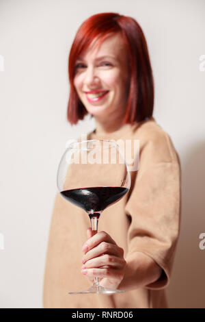 Junge schöne rothaarige Mädchen Sommelier und lächelnd Glas Rotwein am professionellen Blindverkostung sommelier Wettbewerb. Konzept Alkoholismus Stockfoto