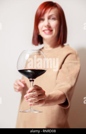 Junge schöne rothaarige Mädchen Sommelier und lächelnd Glas Rotwein am professionellen Blindverkostung sommelier Wettbewerb. Konzept Alkoholismus Stockfoto