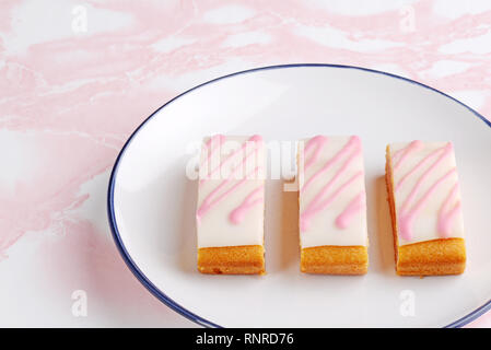 Drei Scheiben englisch Angel cake Slices auf einer Platte Stockfoto
