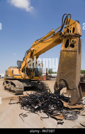 Verfolgt material Handler und Stapel von weggeworfenen Metallbändern an einem Altmetall Recycling Hof Stockfoto