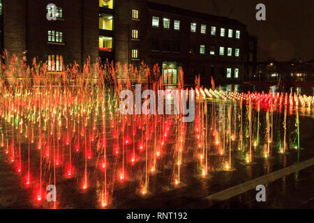 Die beleuchteten Fontänen im Getreidespeicher Square bei Nacht, King's Cross, London, UK Stockfoto