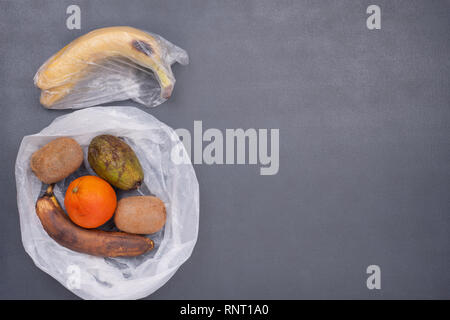 Bild der faulen Früchte und Gemüse in Zellophan Beutel. Null Abfall Konzept. Gemüse und Obst VS Plastiktüten, weil Sie unpreserve wurde Stockfoto