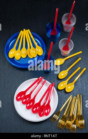 Plastikmüll Gefahr .Ökologie-Konzept mit buntem Einwegbesteck auf schwarzem Hintergrund. Gefälschte Verschmutzung. Stockfoto