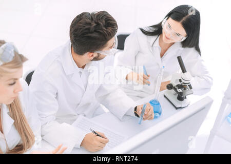 Ansicht von oben. Eine Gruppe von Wissenschaftlern, die auf einem Computer im Labor Stockfoto