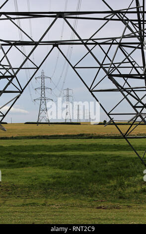 Strommasten dominieren die Landschaft am Oare Sümpfe in der Nähe von Faversham, Kent, Großbritannien. Stockfoto