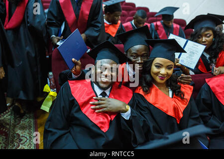 GRODNO, Weißrussland - Juni, 2018: Ausländische afrikanischen Studierenden in eckigen akademische Graduierung Kappen und schwarze Regenmäntel während der Beginn mit diploms Stockfoto