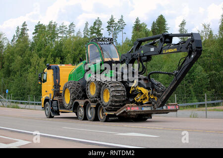 Orivesi, Finnland - 27. August 2018: Gelb Volvo LKW-Transporte neue John Deere Wald Spediteur am Anhänger auf der Autobahn im Sommer, Ansicht von hinten. Stockfoto