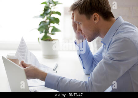 Mann lesen Benachrichtigung von der Bank über unbezahlte Schulden Stockfoto