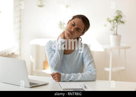 Junge weibliche leidet an Hals Schmerzen am Arbeitsplatz Stockfoto