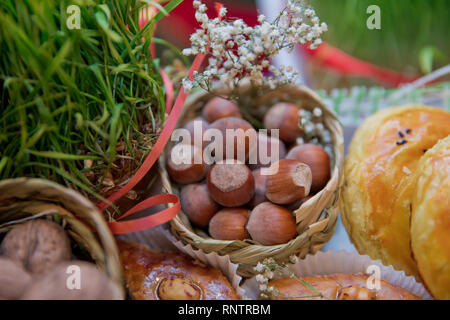 Hazel in einem kleinen Korb. Nahaufnahme der Haselnüsse als Hintergrund. Mischung aus Walnüsse mit harter Schale. Walnüsse, closeup getrocknet. Stockfoto