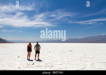 Ein paar Besucher blicken auf die Salzpfanne, Badwater Basin, Death Valley National Park, California, United States. Stockfoto