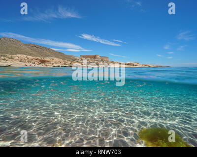 Spanien Mittelmeerküste mit einem Schloss und Schule der Fische (BOGUE) mit Sand unter Wasser Meer, El Playazo de Rodalquilar, Almeria, Andalusien, geteilte Ansicht Stockfoto