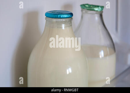 Wiederverwendbare Glas Milch Flaschen sind wieder in Mode in Großbritannien so viele Verbraucher ihr Bestes tun, um zu verringern, wiederverwenden und recyceln. Ganze und halb entrahmte organische Stockfoto