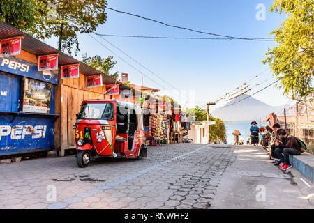 Panajachel, Atitlan See, Guatemala - Dezember 29, 2018: Einheimische und Tuk Tuks warten oben Jetty für öffentliche Boote vorangegangen Dörfer in Panajachel nach Lakeside Stockfoto