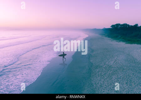 Surfer Silhouette in den Ozean Wasser bei Sonnenaufgang am Morgen Nebel Stockfoto