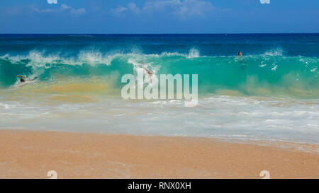 WAIKIKI, VEREINIGTE STAATEN VON AMERIKA - 6. AUGUST 2015: ein Schuß von Körper Surfer am sandigen Strand Stockfoto