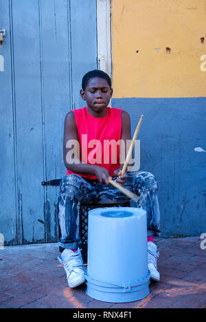 Junger afroamerikanischer Straßenmusiker trommelt auf einem Plastikeimer in der Bourbon Street, New Orleans French Quarter New Orleans, Louisiana, USA Stockfoto