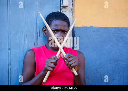 Portrait des jungen afroamerikanischen Straßenschlagerjungen, der mit einer Kamera die Schlagstöcke auf der Bourbon Street im New Orleans French Quarter New Orleans hält Stockfoto