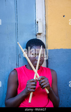 Portrait des jungen afroamerikanischen Straßenschlagerjungen, der mit einer Kamera die Schlagstöcke auf der Bourbon Street im New Orleans French Quarter New Orleans hält Stockfoto