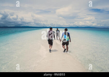 3 chinesische Männer gehen auf Weiße Sandbank auf Island Hopping Tour - Kalanggaman, Leyte, Philippinen Stockfoto