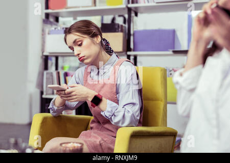 Unzufrieden lady Kontrolle ihr Smartphone, während ihr Freund reden Langweilig Stockfoto