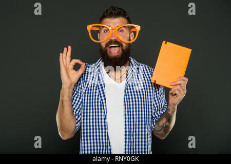 Buchen Sie das Deckblatt kopieren. Hipster bärtiger Mann tragen lustige Brillen notepad oder Buch halten. Hellen Sie ihren Tag. Lesen Sie dieses Buch. Comic und Humor Sinn. Diese Geschichte gerade mein Tag. Lustiges Buch für entspannen. Stockfoto