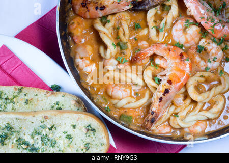 Handgearbeitete sardische Spezialitäten Pasta, Lorighittas, mit Garnelen und Meeresfrüchte Sauce in die Pfanne bereit zu dienen. Stockfoto