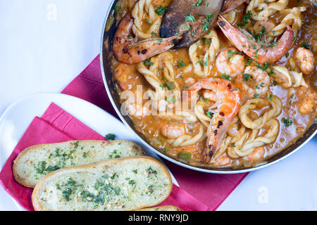 Handgearbeitete sardische Spezialitäten Pasta, Lorighittas, mit Garnelen und Meeresfrüchte Sauce in die Pfanne bereit zu dienen. Stockfoto